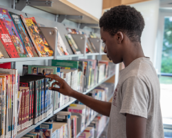 A teen is looking at graphic novels.