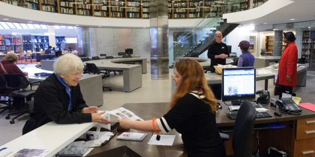 Staff helping customers in library reading room